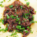 Overhead close-up vegan mushroom ragu sauce served with creamy polenta.