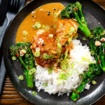 Overhead Filipino chicken adobo with coconut milk served with stir fried broccoli and rice.