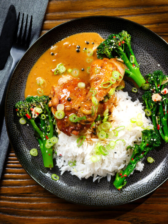 Overhead Filipino chicken adobo with coconut milk served with stir fried broccoli and rice.