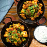 Overhead Indian aloo gobi matar ki sabzi: Dry vegan potato, cauliflower and pea curry.