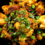 Close-up overhead Indian aloo gobi matar ki sabzi: Dry vegan potato, cauliflower and pea curry.