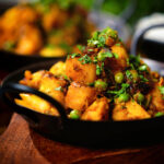 Close-up Indian aloo gobi matar ki sabzi: Dry vegan potato, cauliflower and pea curry.