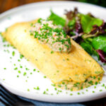 Crab meat and creme fraiche stuffed omelette served with a side salad.