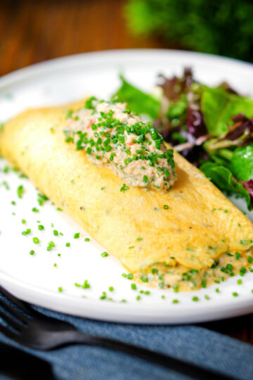 Crab meat and creme fraiche stuffed omelette served with a side salad.