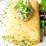 Crab meat and creme fraiche stuffed omelette served with a side salad and snipped chives.