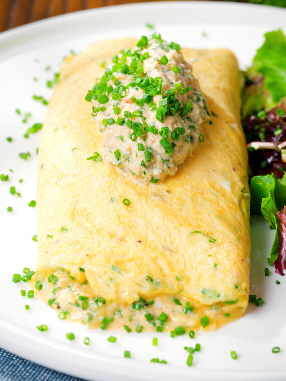 Crab meat and creme fraiche stuffed omelette served with a side salad and snipped chives.