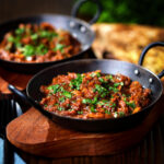 Keralan beef curry served in a karahi with fresh coriander and naan bread.