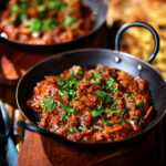 Keralan style beef curry served with fresh coriander and naan bread.