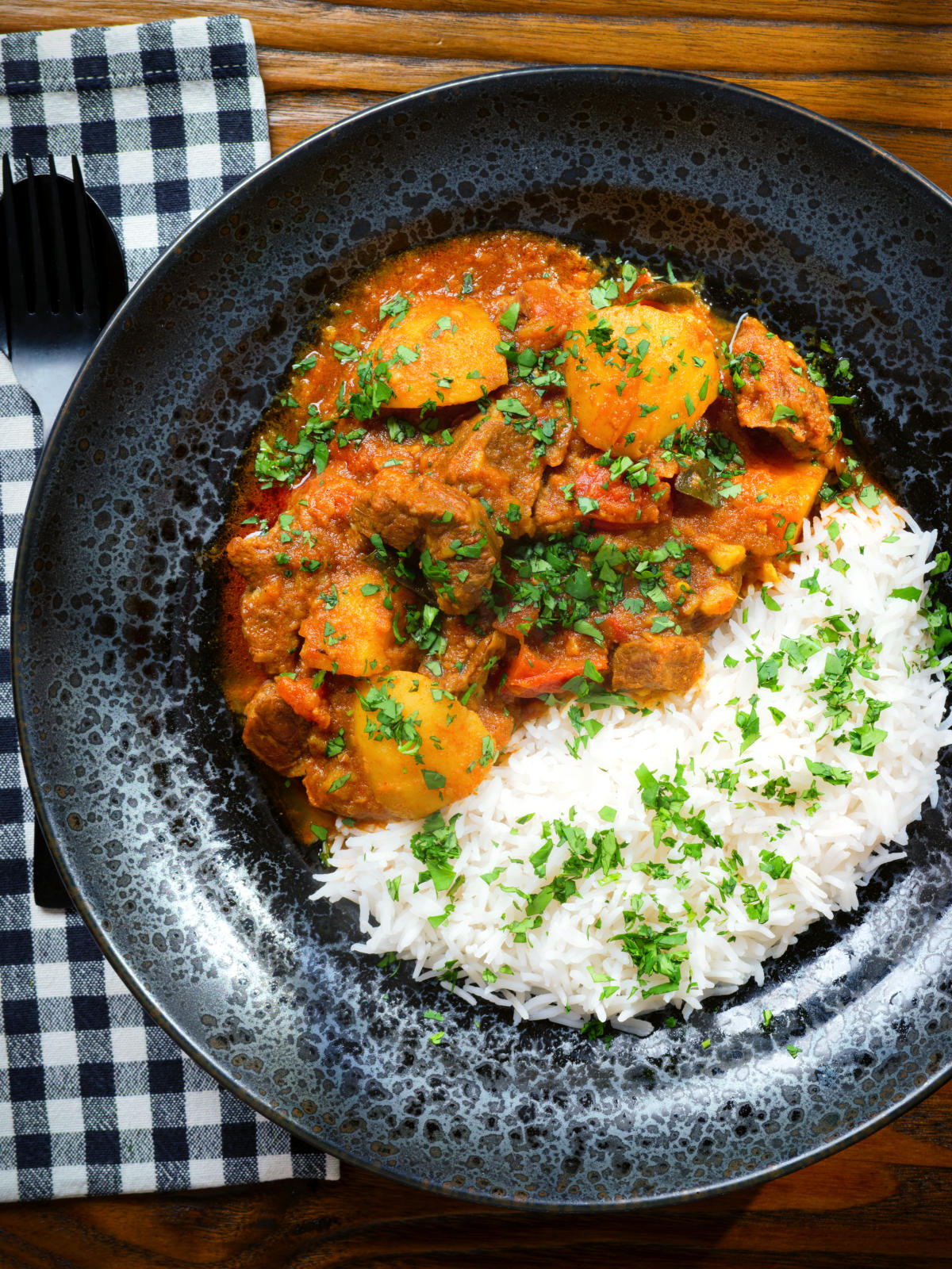 Overhead South African influenced lamb and potato Durban curry served with rice.