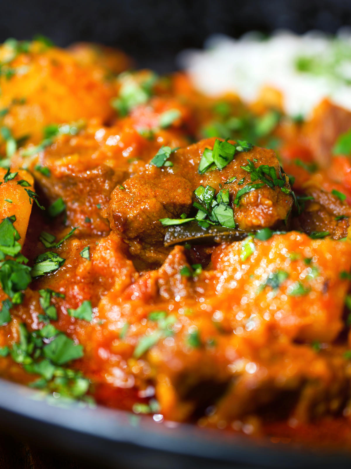 Close-up South African influenced lamb and potato Durban curry served with rice.