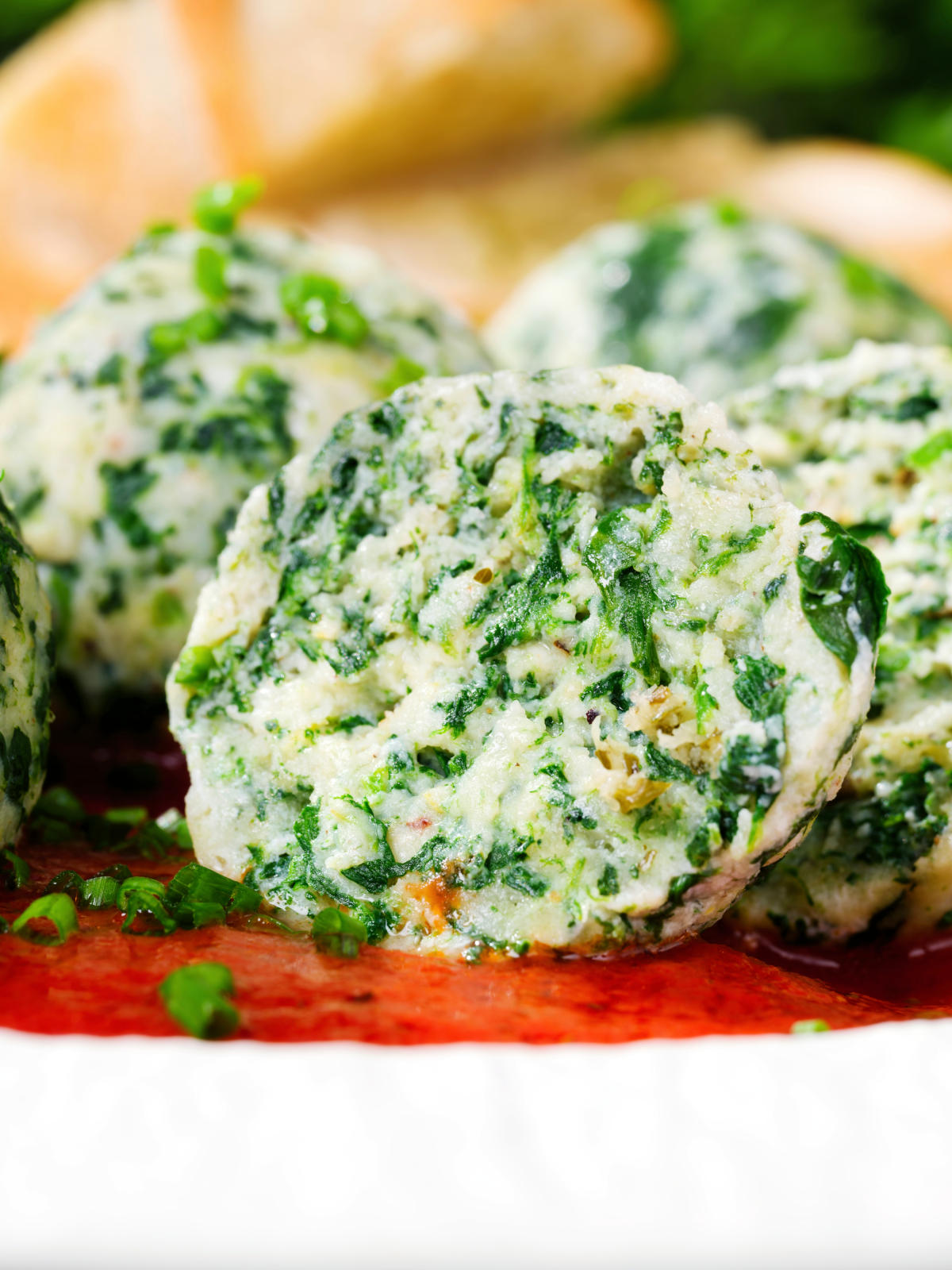 Cut open Italian Malfatti (spinach and ricotta dumplings) with tomato sauce and garlic bread.