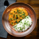 Indian nawabi chicken curry with basmati rice and coriander served in a bowl.