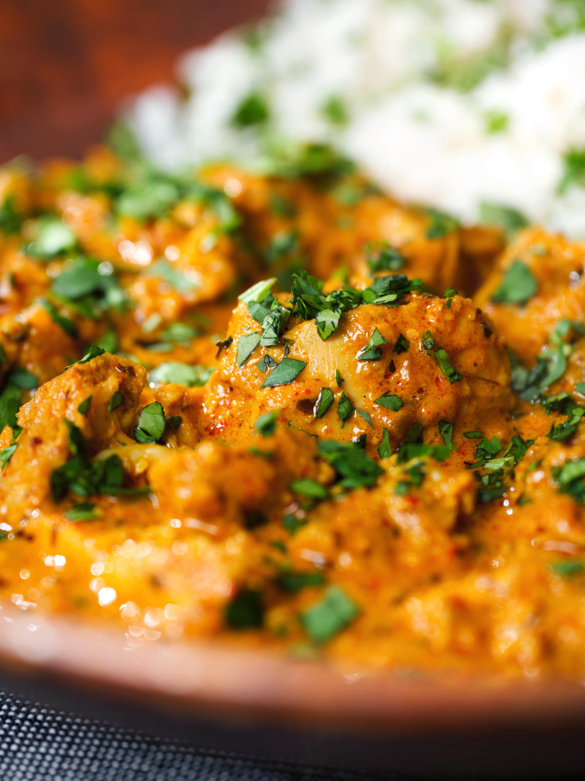 Close-up Indian nawabi chicken curry with basmati rice and coriander.