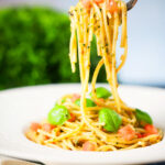 Close-up Sicilian pesto alla trapanese served with spaghetti on a fork.