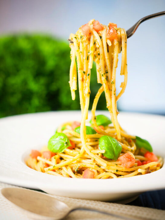 Close-up Sicilian pesto alla trapanese served with spaghetti on a fork.