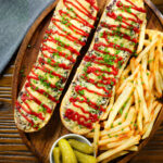Overhead Polish cheese and mushroom zapiekanka open sandwich served with ketchup and fries.