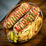 Polish cheese and mushroom zapiekanka open faced sandwich served with ketchup and French fries.