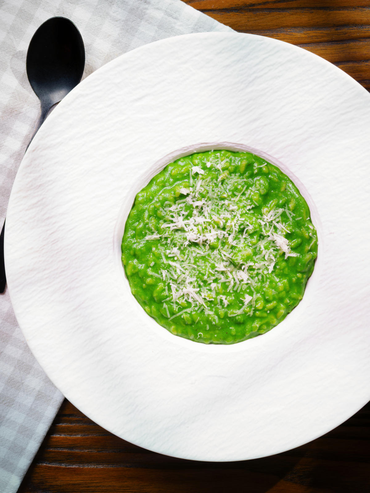 Overhead risotto verde with spinach, green peas and broad beans.