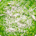 Close-up overhead risotto verde with spinach, green peas and broad beans.
