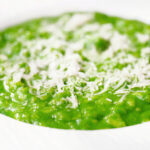 Close-up risotto verde with spinach, green peas and broad beans.