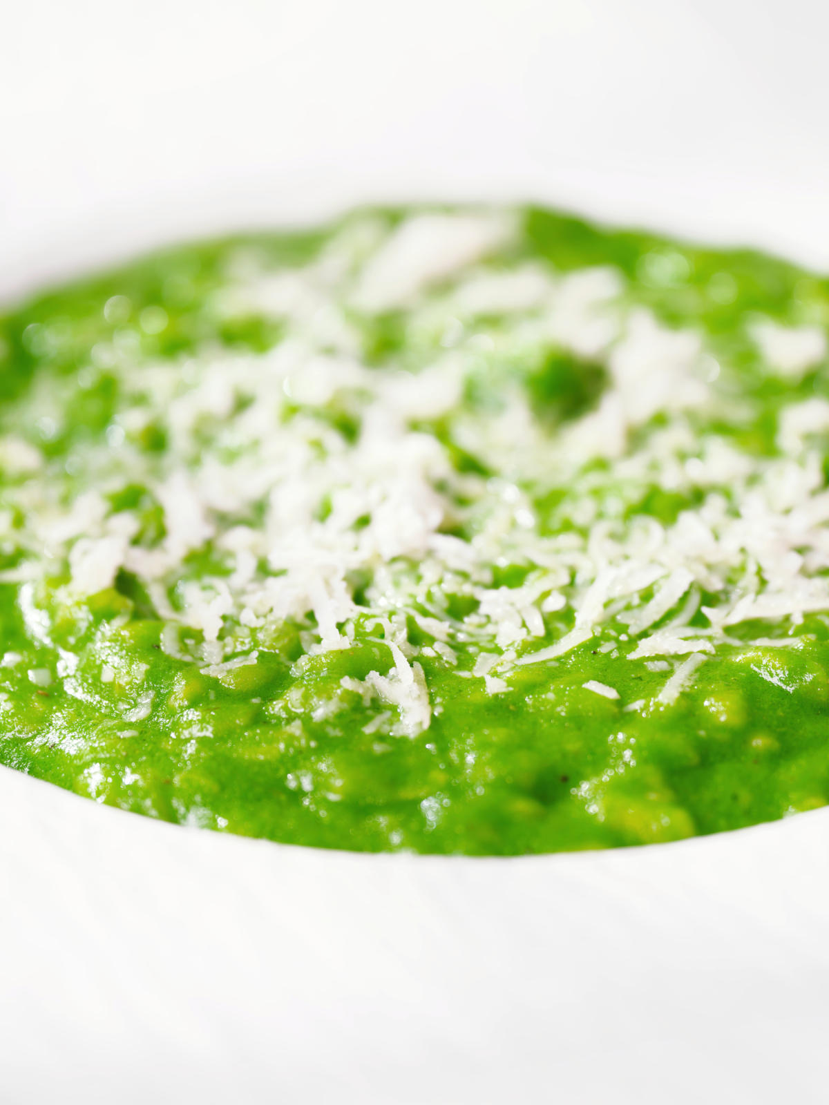 Close-up risotto verde with spinach, green peas and broad beans.