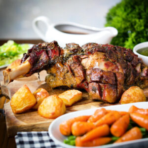 Slow roasted lamb shoulder with roast potatoes, cabbage, carrots, and green beans.