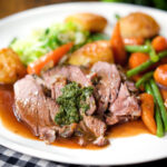 Sunday lunch of slow roasted lamb shoulder with roast potatoes, veggies, mint sauce and gravy.
