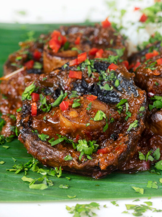 Close-up vegan mushroom rendang curry served with rice, fresh chilli and coriander.