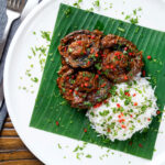 Overhead vegan mushroom rendang curry served with rice, fresh chilli and coriander.