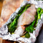 Baked fish (rainbow trout) cooked in foil with asparagus and tenderstem broccoli.