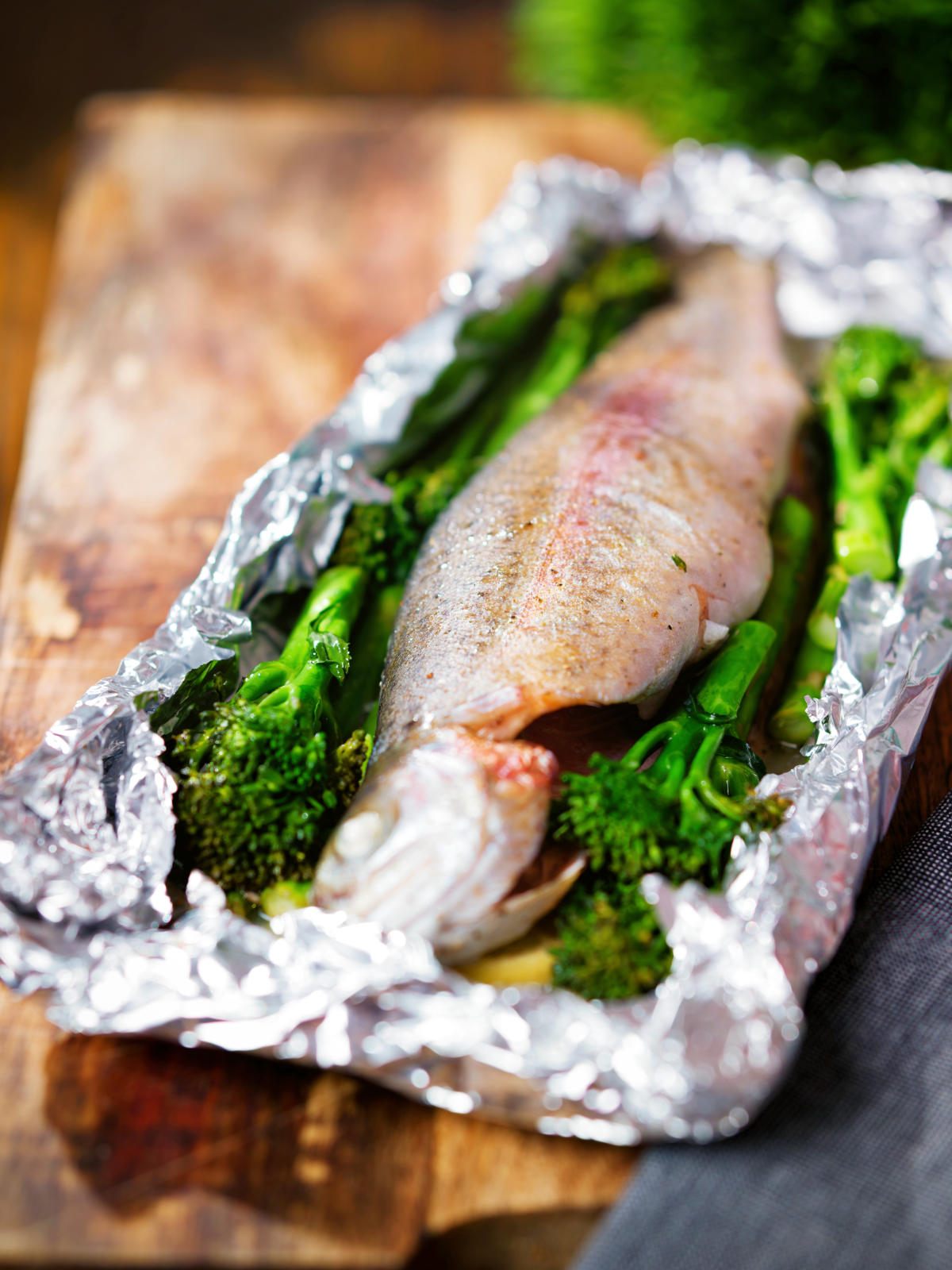 Baked fish (rainbow trout) cooked in foil with asparagus and tenderstem broccoli.