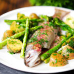 Baked fish (rainbow trout) that was cooked in foil with asparagus and tenderstem broccoli, served with buttered potatoes.