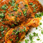 Close-up overhead Indian chicken kolhapuri curry served with rice and coriander.