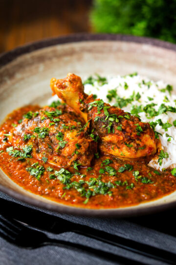 Indian chicken kolhapuri curry served with rice and coriander.