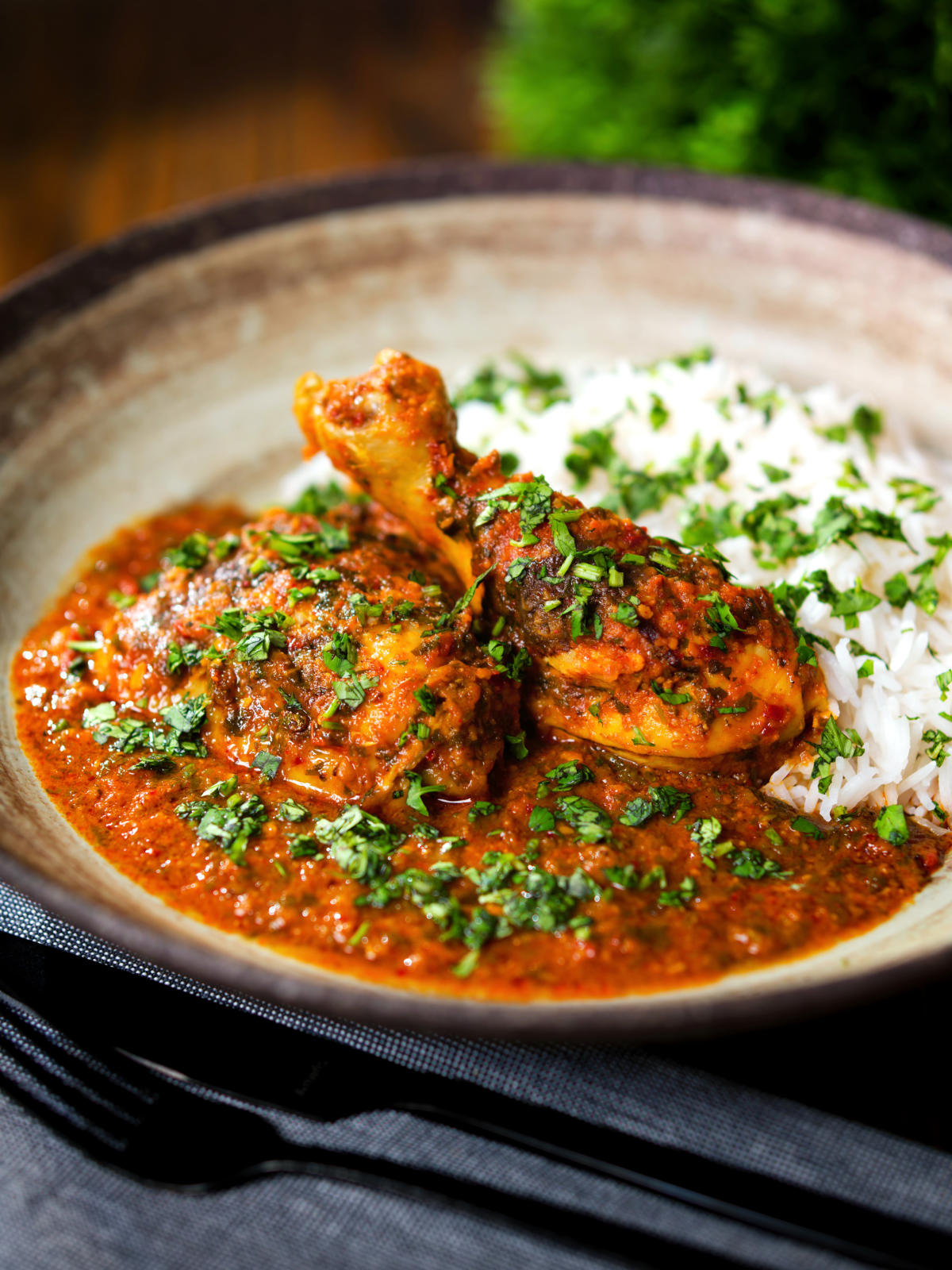 Indian chicken kolhapuri curry served with rice and coriander.
