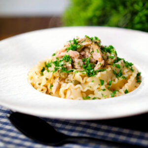 Garlic, lemon and caper chicken piccata pasta garnished with fresh parsley.