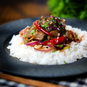 Chinese Xinjiang lamb stir fry with cumin and red onion served with jasmine rice.