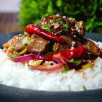 Chinese Xinjiang lamb stir fry with cumin, dried chillies and red onion served with rice.