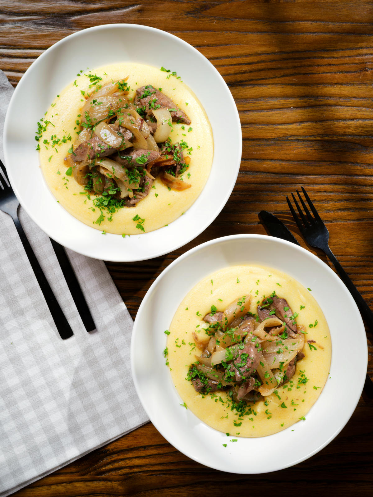 Overhead Fegato alla Veneziana (Italian fried liver and onions) served with polenta.