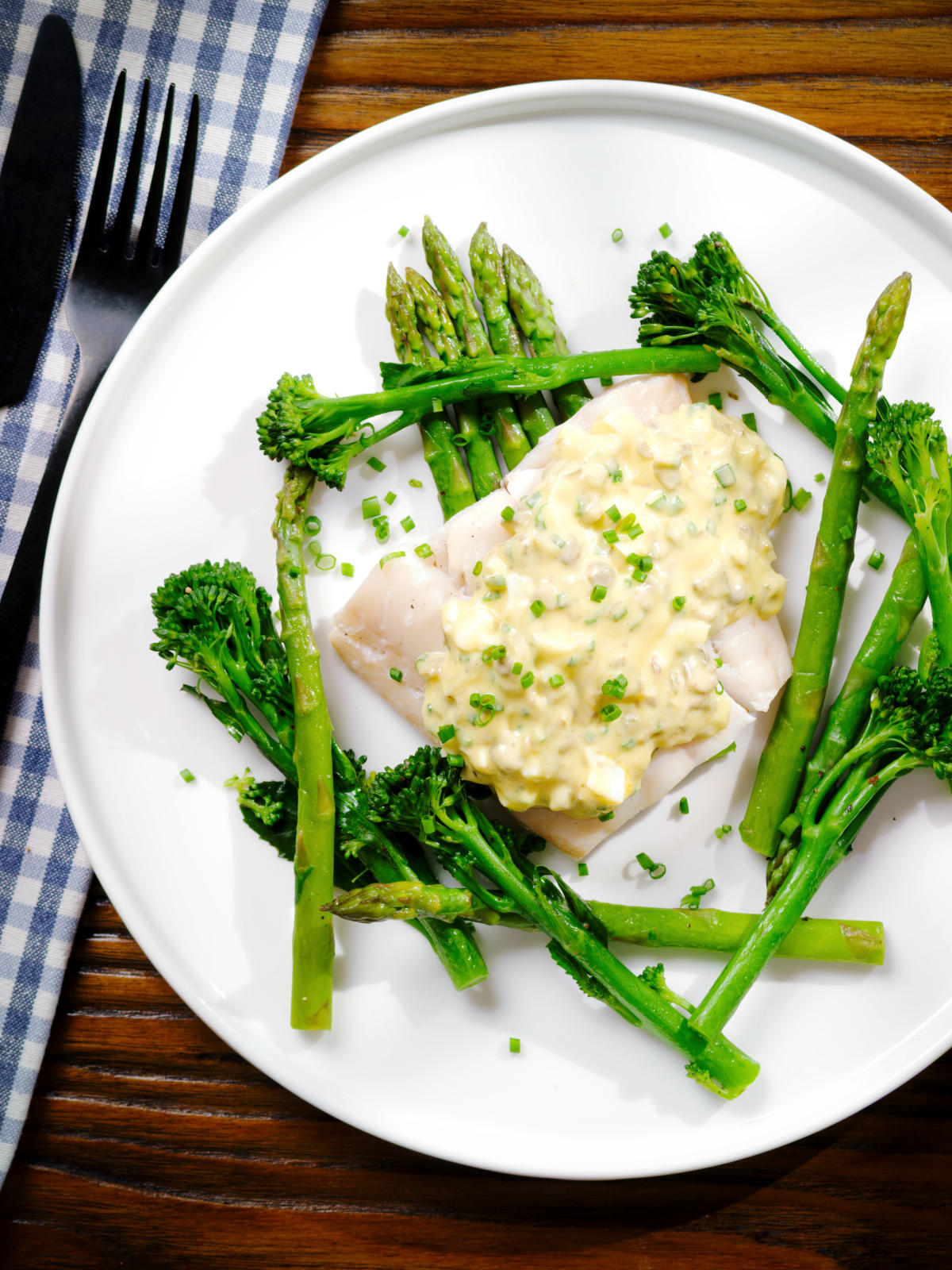 Overhead poached smoked haddock with sauce gribiche, asparagus and tenderstem broccoli.