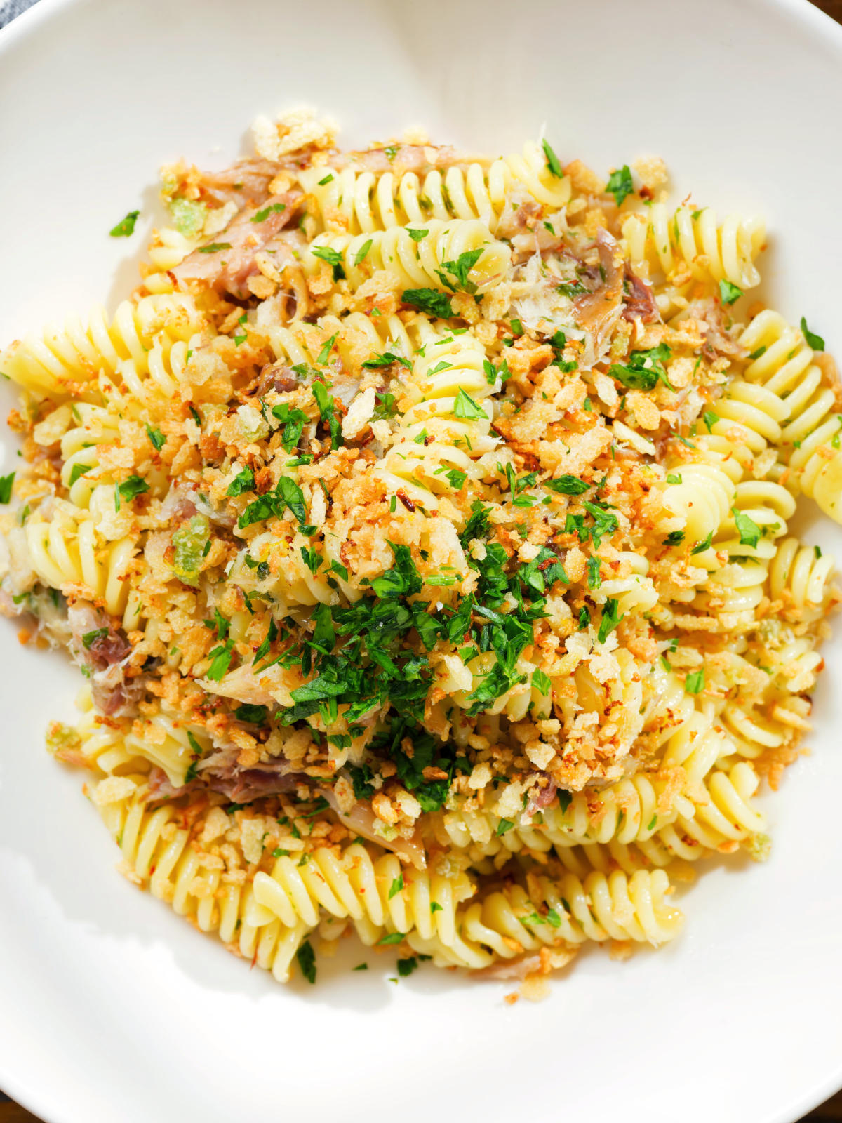 Close-up overhead smoked mackerel pasta (fusilli) with chilli and a lemon crumb.