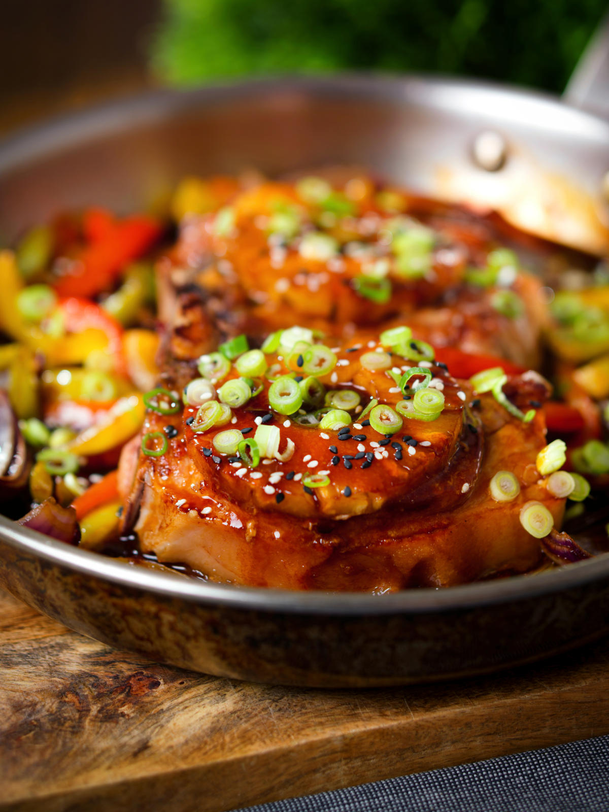 Sweet and sour pork chops with peppers, red onion and pineapple, served in a pan.