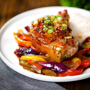 Sweet and sour pork chops with peppers, red onion and pineapple, served with rice.