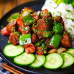 Vietnamese shaking beef (bò lúc lắc) served with cucumber, jasmine rice and lettuce.