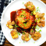 Overhead baked Hawaiian chicken breast with pineapple huli huli sauce and crushed new potatoes.