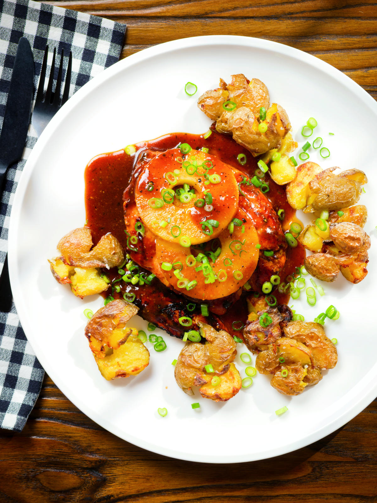 Overhead baked Hawaiian chicken breast with pineapple huli huli sauce and crushed new potatoes.