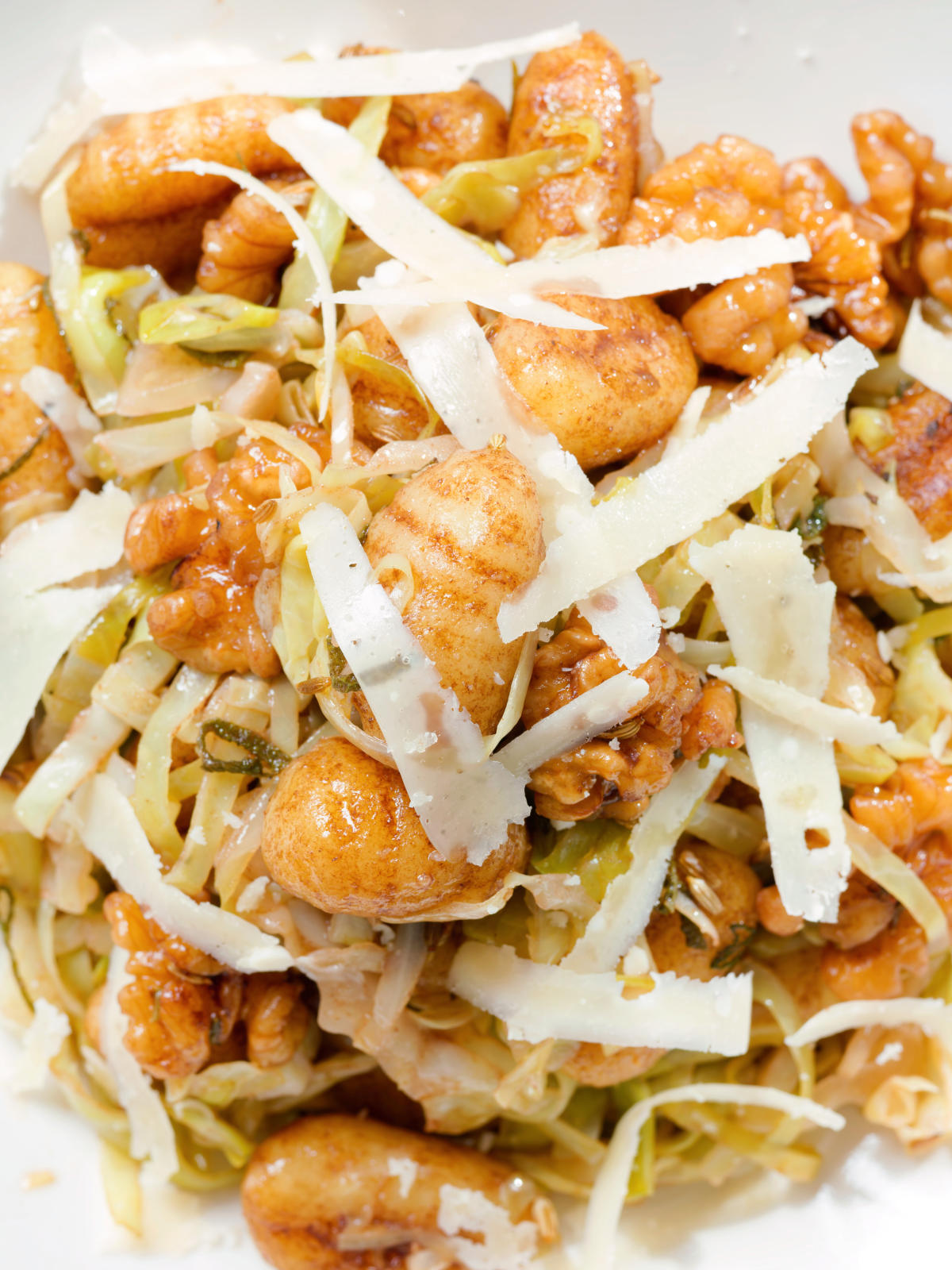 Close-up overhead pan fried cabbage and walnut gnocchi with balsamic vinegar.