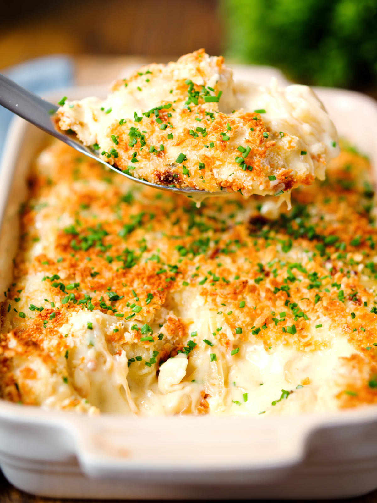 Cheddar cheese and onion baked gnocchi gratin on a spoon.