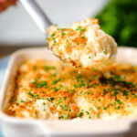 Cheddar cheese and onion baked gnocchi gratin on a spoon.