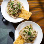 Overhead creamy garlic mushroom pasta served with fresh parsley and garlic bread.